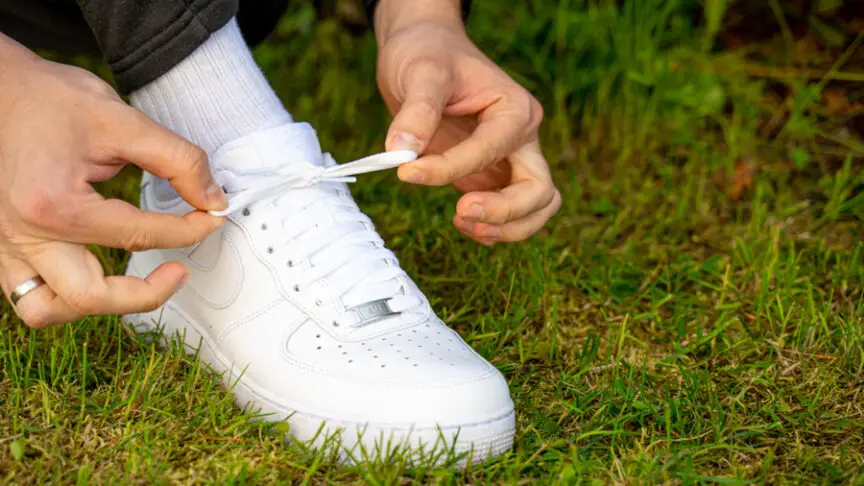 man tying air force one shoes